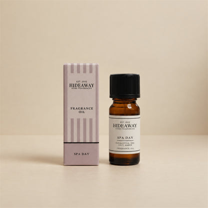 Hideaway Home Fragrances spa day fragrance oil bottle standing against a seamless neutral studio backdrop.
