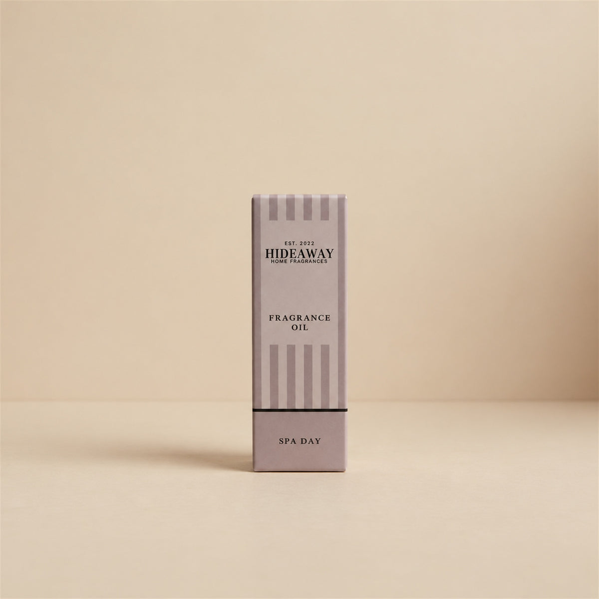Packaged Hideaway Home Fragrances spa day fragrance oil bottle standing beside its luxury retail box highlighting herbal pine, floral lily, and natural wood notes.