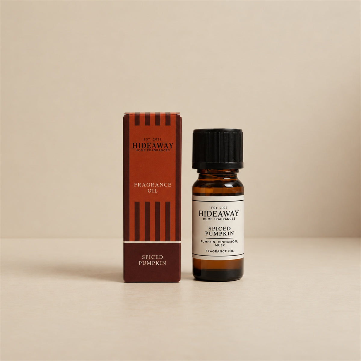 Hideaway Home Fragrances spiced pumpkin fragrance oil bottle standing against a seamless neutral studio backdrop.