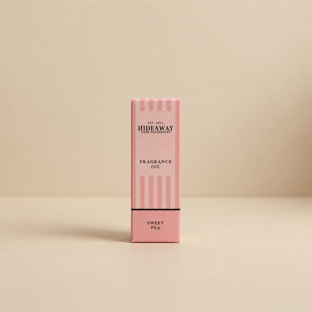 Packaged Hideaway Home Fragrances sweet pea fragrance oil bottle standing beside its luxury retail box highlighting delicate rose, jasmine, and creamy vanilla notes.