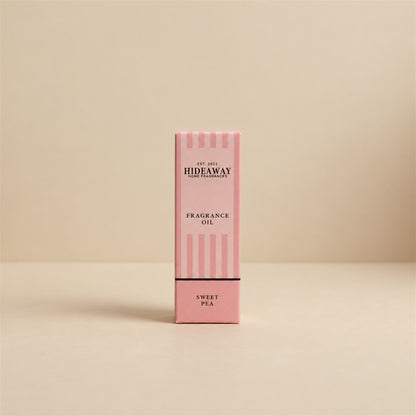 Packaged Hideaway Home Fragrances sweet pea fragrance oil bottle standing beside its luxury retail box highlighting delicate rose, jasmine, and creamy vanilla notes.