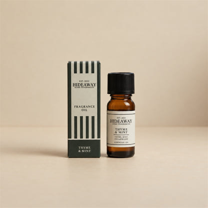 Hideaway Home Fragrances thyme and mint fragrance oil bottle standing against a seamless neutral studio backdrop.