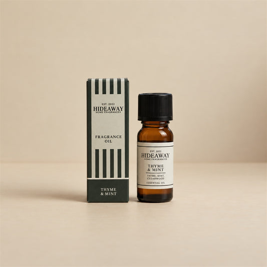 Hideaway Home Fragrances thyme and mint fragrance oil bottle standing against a seamless neutral studio backdrop.