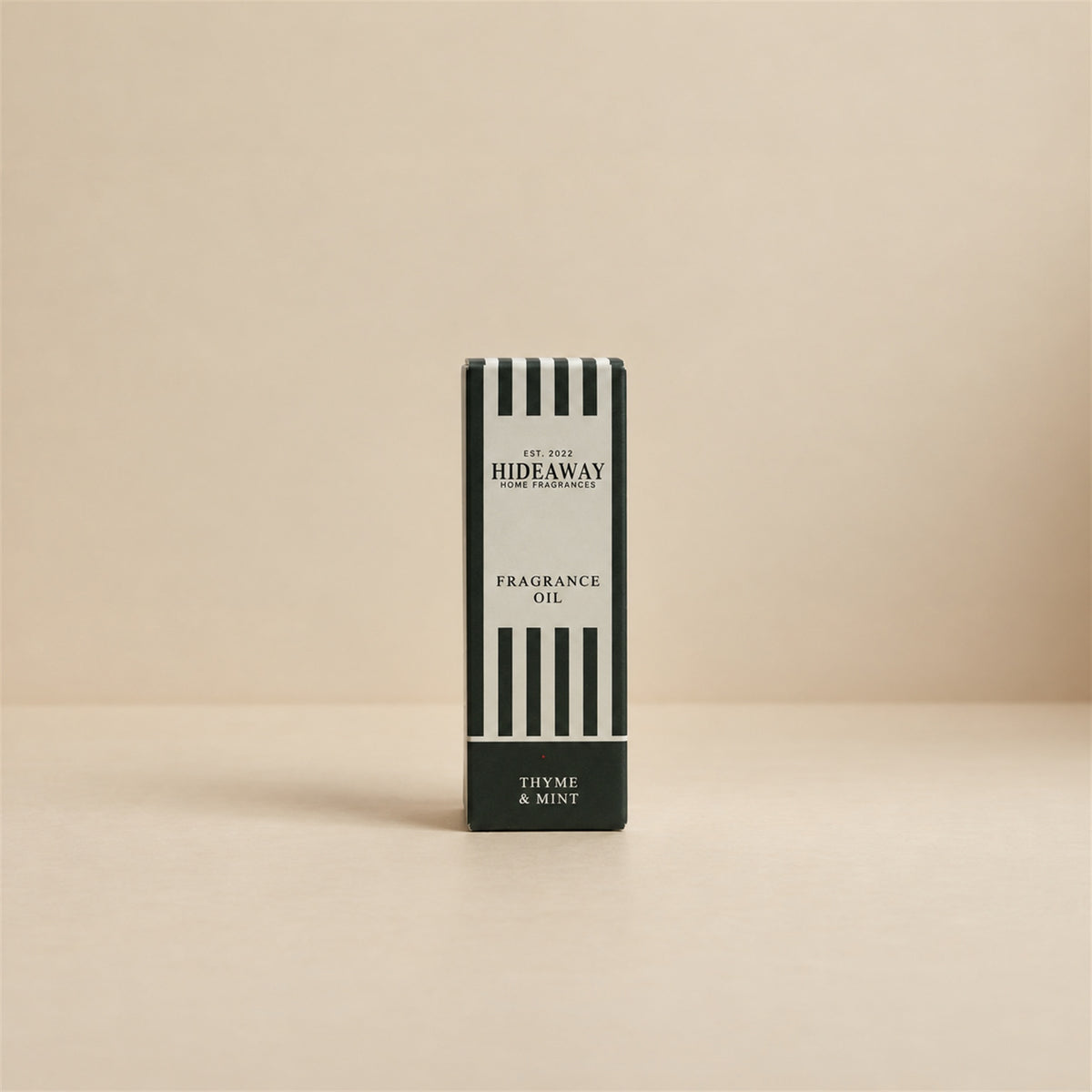 Packaged Hideaway Home Fragrances thyme and mint fragrance oil bottle standing beside its luxury retail box highlighting zesty bergamot, marjoram, and cedarwood notes.