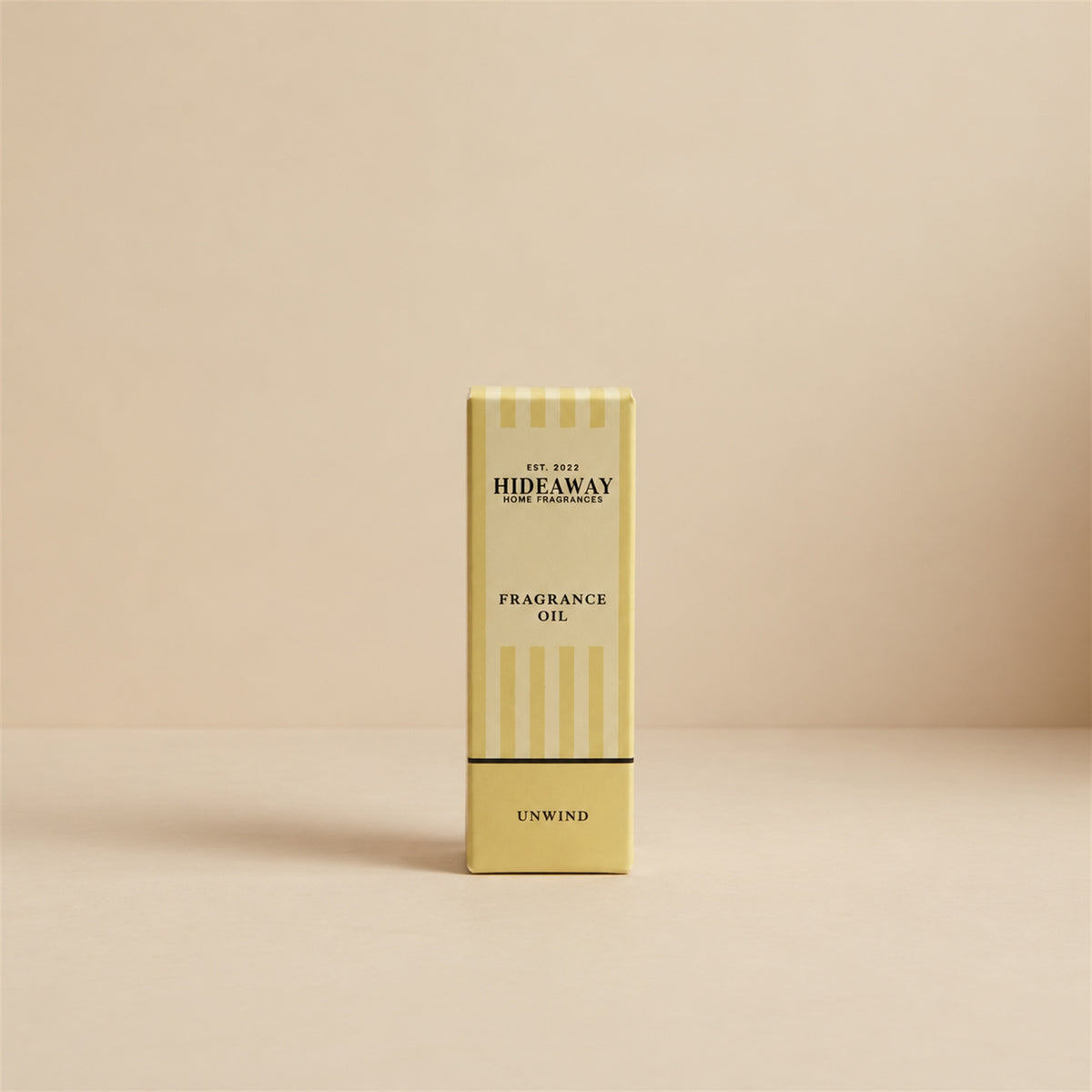 Packaged Hideaway Home Fragrances unwind fragrance oil bottle standing beside its luxury retail box highlighting relaxing herbal and citrus aromatherapy notes.