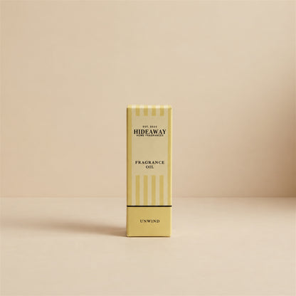 Packaged Hideaway Home Fragrances unwind fragrance oil bottle standing beside its luxury retail box highlighting relaxing herbal and citrus aromatherapy notes.