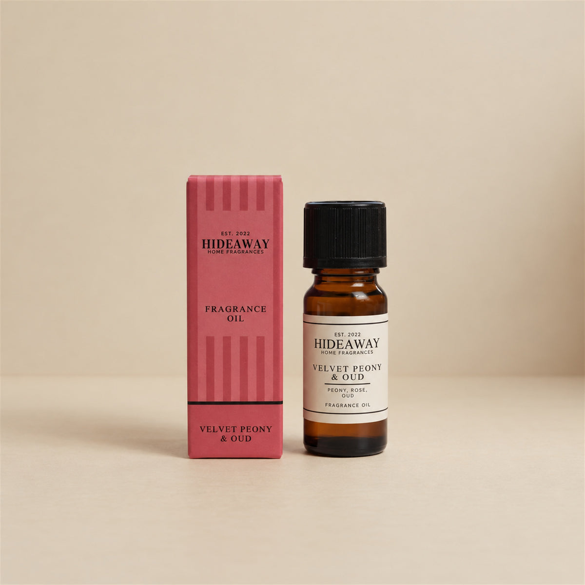 Hideaway Home Fragrances velvet peony and oud fragrance oil bottle standing against a seamless neutral studio backdrop.