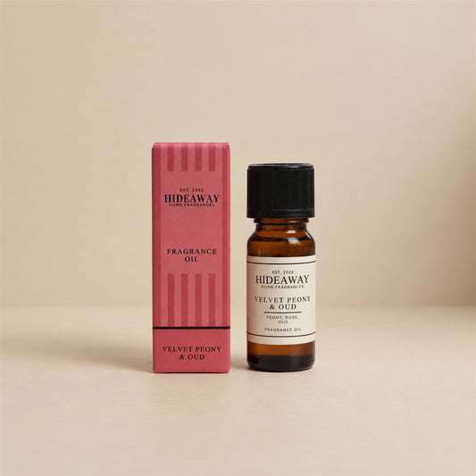 Hideaway Home Fragrances velvet peony and oud fragrance oil bottle standing against a seamless neutral studio backdrop.