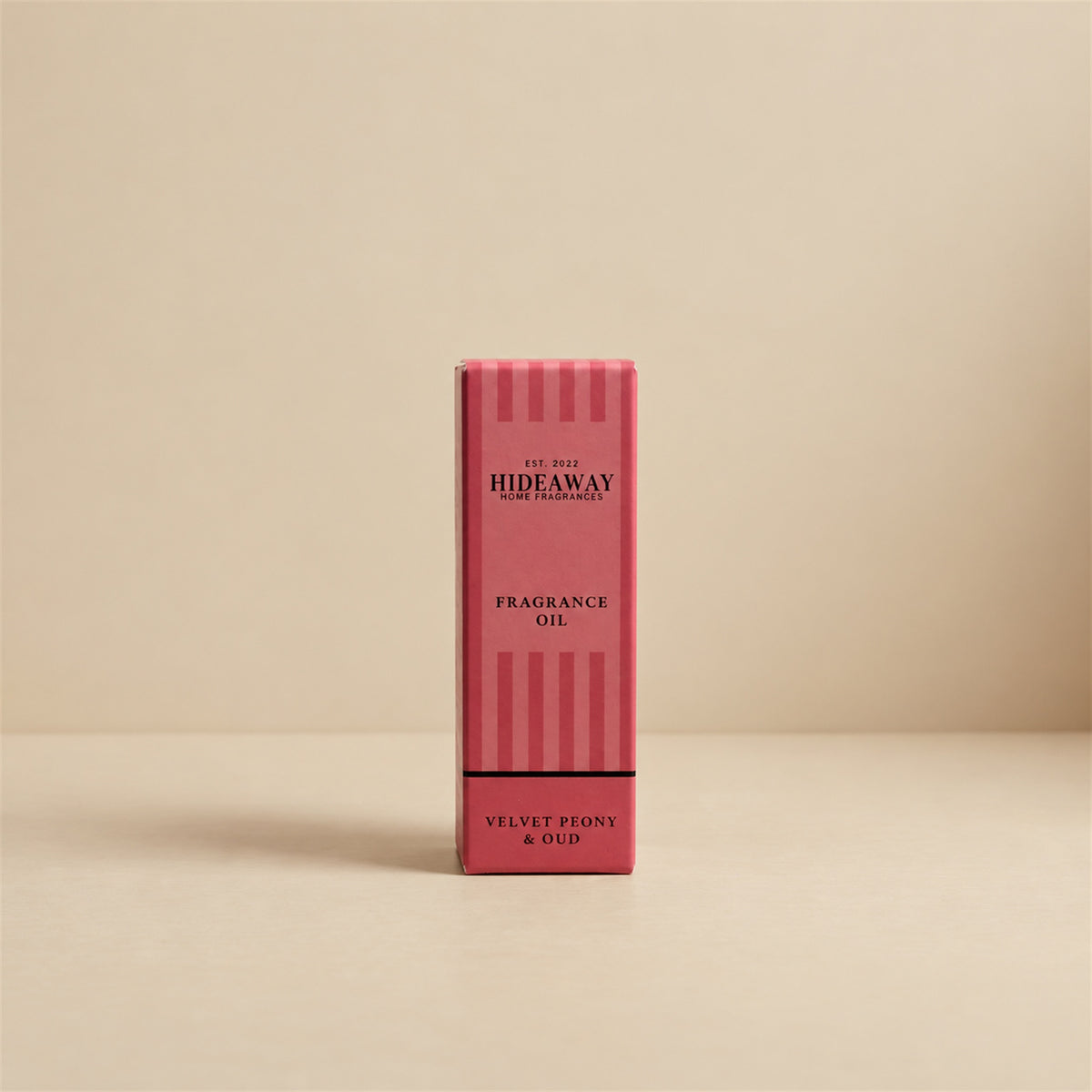 Packaged Hideaway Home Fragrances velvet peony and oud fragrance oil bottle standing beside its luxury retail box highlighting spicy clove, amber, and rich vanilla base notes.
