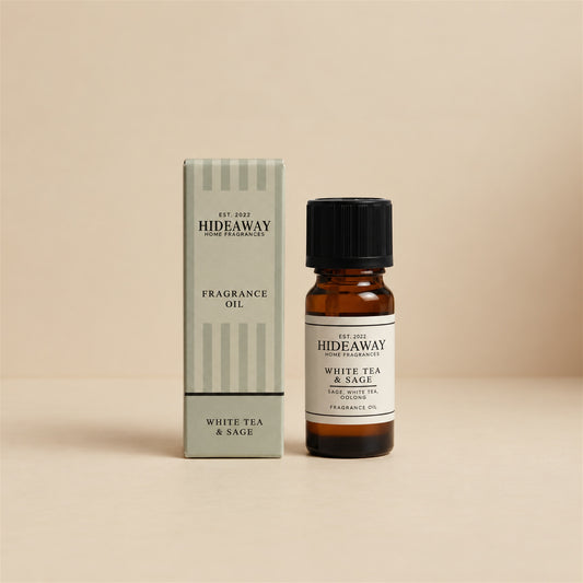 Hideaway Home Fragrances white tea and sage fragrance oil bottle standing against a seamless neutral studio backdrop.
