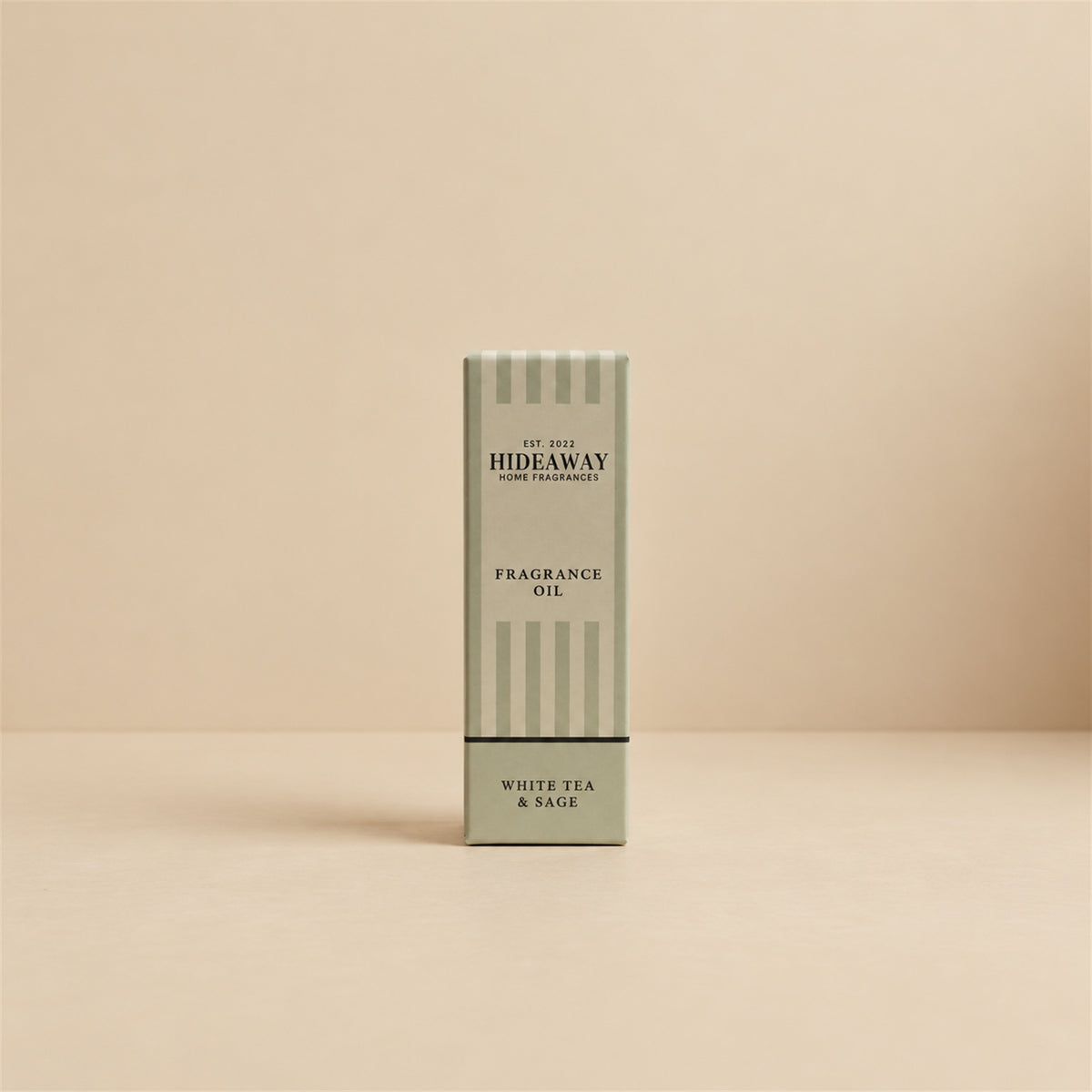 Packaged Hideaway Home Fragrances white tea and sage fragrance oil bottle standing beside its luxury retail box highlighting herbal thyme and soothing tea notes.