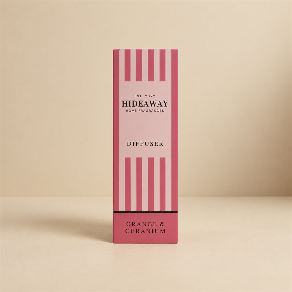 Hideaway Home Fragrances orange and geranium reed diffuser bottle with natural reeds on a shelf