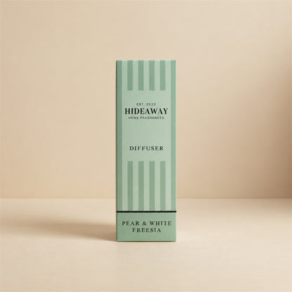 Hideaway Home Fragrances pear and white freesia reed diffuser on a bright entryway console table