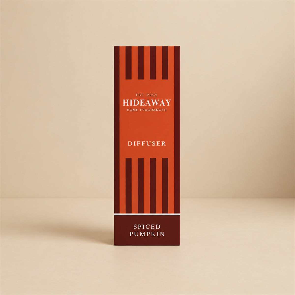Hideaway Home Fragrances spiced pumpkin reed diffuser bottle with natural reeds on a rustic wooden table