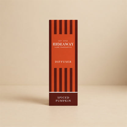 Hideaway Home Fragrances spiced pumpkin reed diffuser bottle with natural reeds on a rustic wooden table