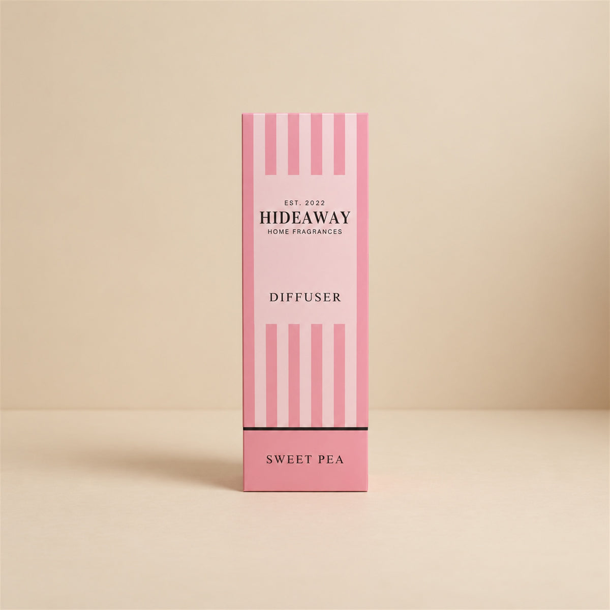 Hideaway Home Fragrances sweet pea reed diffuser bottle with natural reeds on a bedside table