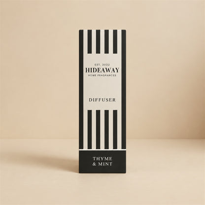 Hideaway Home Fragrances thyme and mint reed diffuser bottle with natural reeds on a kitchen windowsill