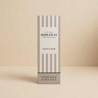 Hideaway Home Fragrances wood sage and sea salt reed diffuser bottle with natural reeds on a console table
