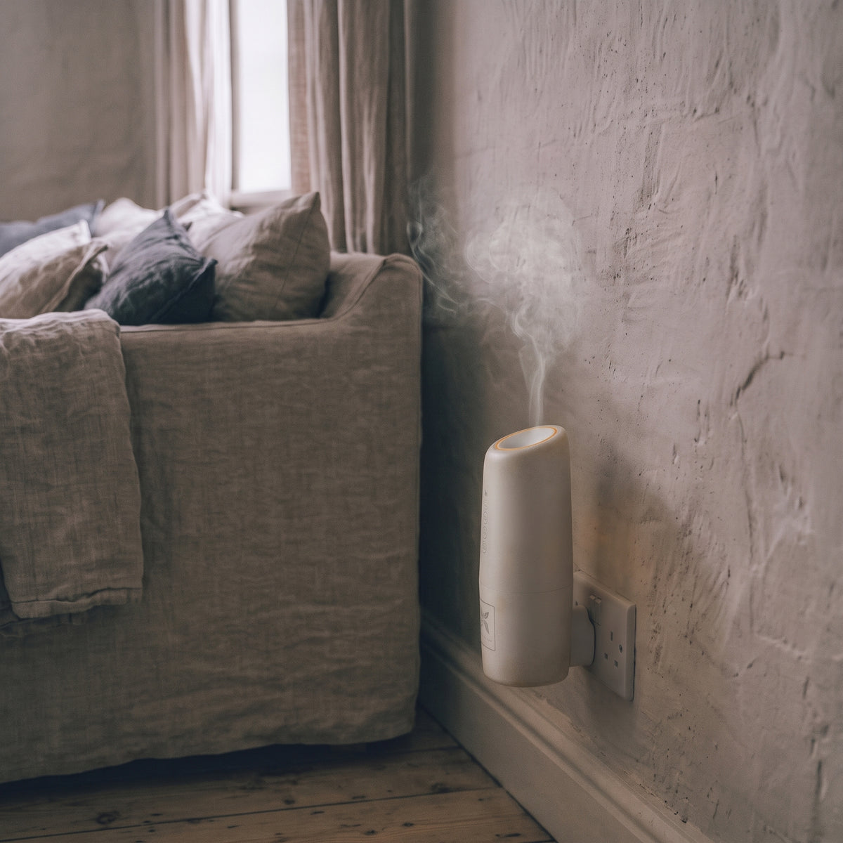 The Kapplico Waterless Plug-In Diffuser by Hideaway Home Fragrances plugged into a hallway electrical outlet, styled in a cozy home entryway.