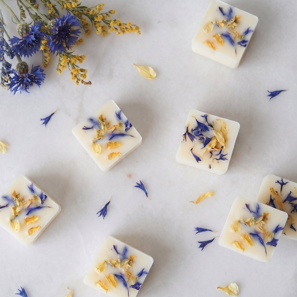 Fresh wood sage and sea salt wax melt cube melting in a ceramic burner dish by Hideaway Home Fragrances releasing ozone and citrus aromas