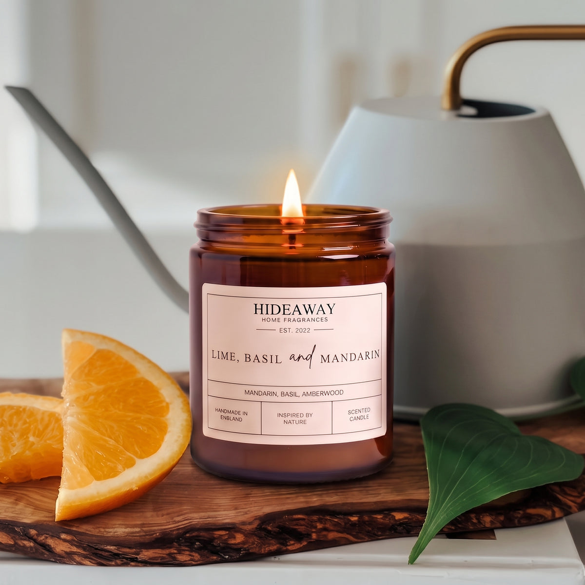 Vibrant lime, basil and mandarin amber glass jar candle styled on a sunlit marble countertop, Hideaway Home Fragrances