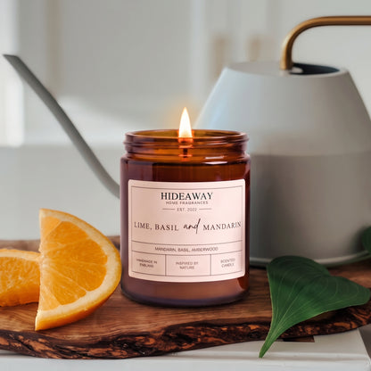 Vibrant lime, basil and mandarin amber glass jar candle styled on a sunlit marble countertop, Hideaway Home Fragrances