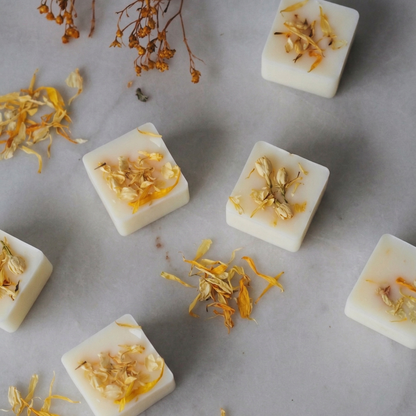 Close-up of handmade natural soy wax melts topped with dried basil and citrus botanicals - Hideaway Home Fragrances