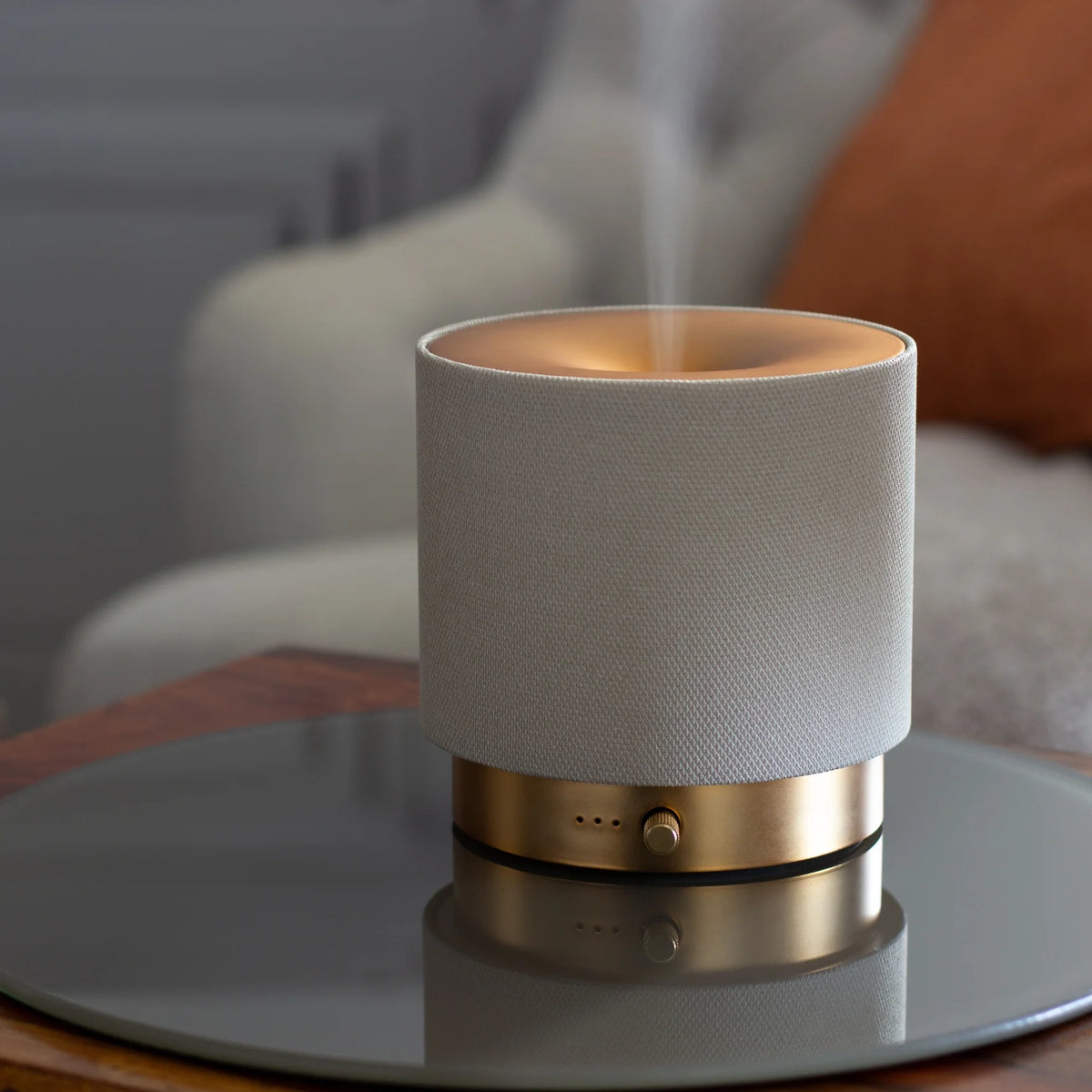 Compact Mira USB Aroma Diffuser by Hideaway Home Fragrances connected via USB cable next to a laptop on a home office desk