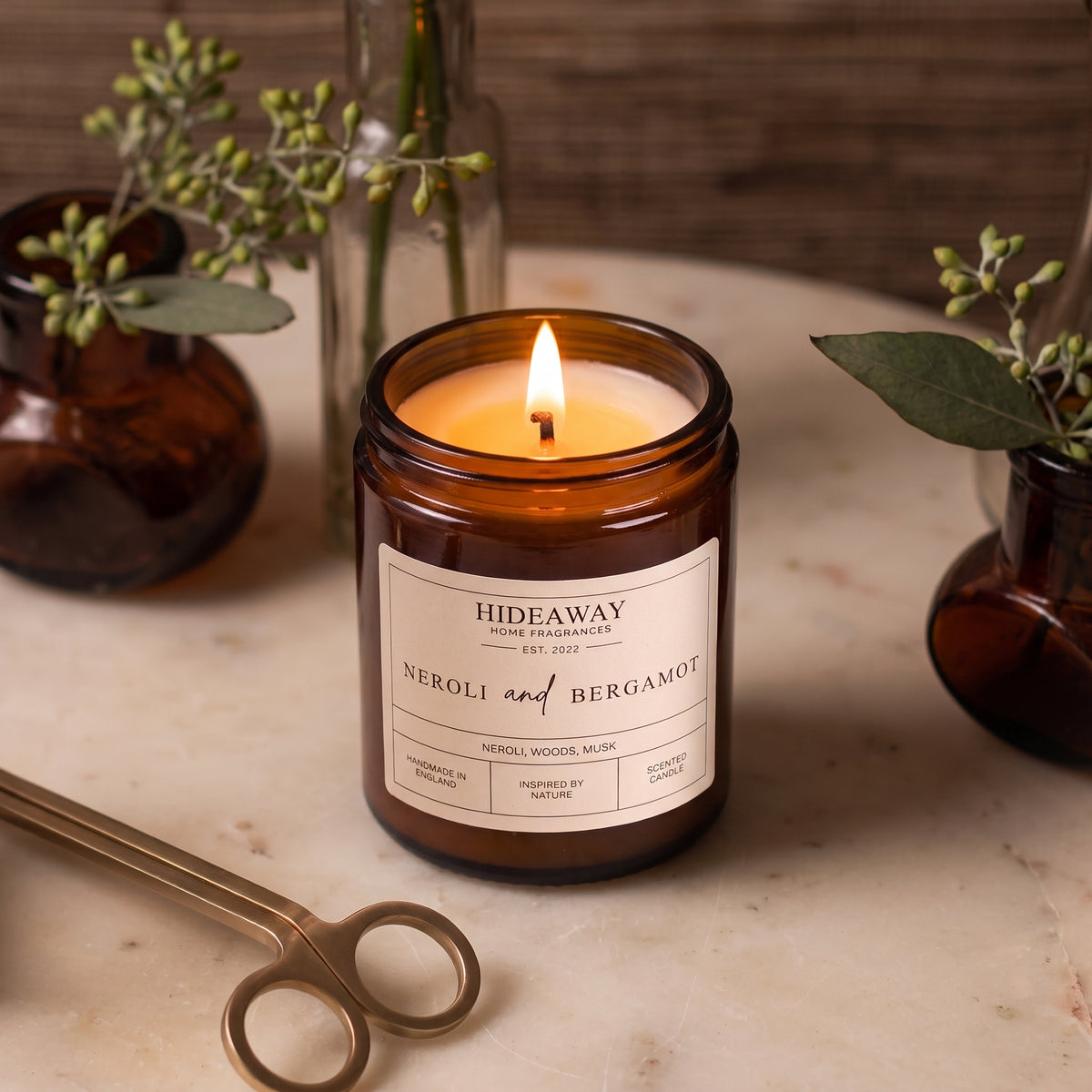 Bright neroli and bergamot amber glass jar candle styled in a sunlit spa bathroom, Hideaway Home Fragrances