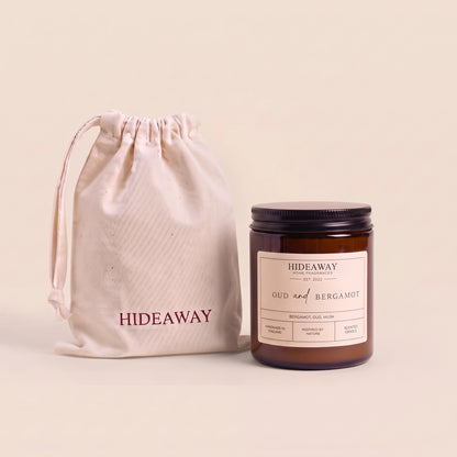 Sophisticated oud and bergamot aromatic candle in an amber glass jar creating a warm cozy atmosphere from Hideaway Home Fragrances
