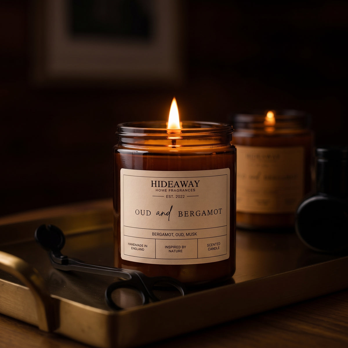 Luxurious oud and bergamot amber glass jar candle styled on a moody dark wood mantel, Hideaway Home Fragrances