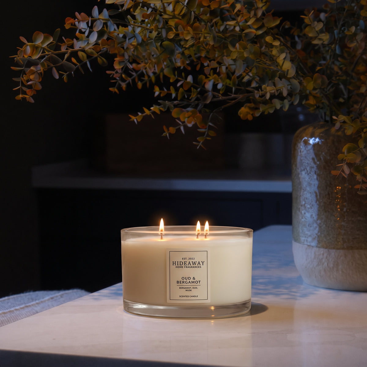 Oud and Bergamot 3-wick luxury candle with smoky, spiced aroma creating a warm and sophisticated evening atmosphere