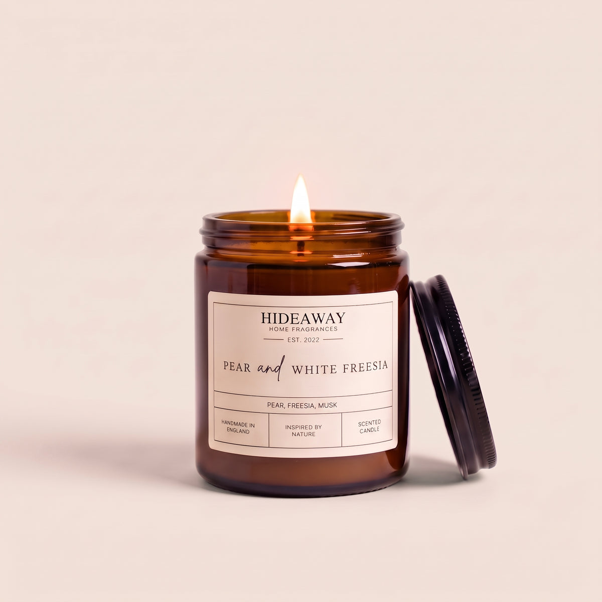 Hand-poured pear and white freesia amber glass candle featuring sweet juicy pear and delicate white freesia notes, Hideaway Home Fragrances
