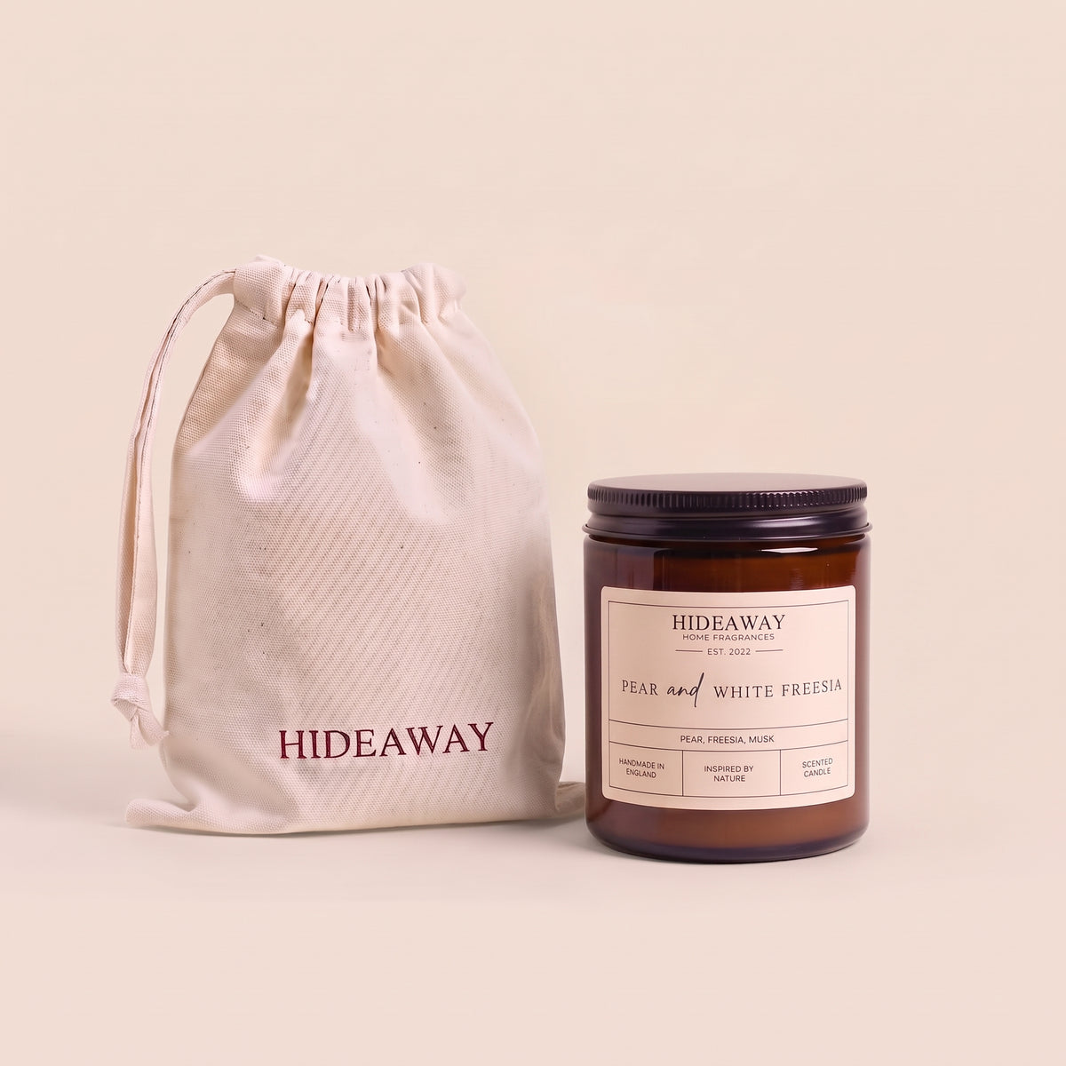 Fresh pear and white freesia aromatic candle in an amber glass jar creating an elegant spring atmosphere from Hideaway Home Fragrances