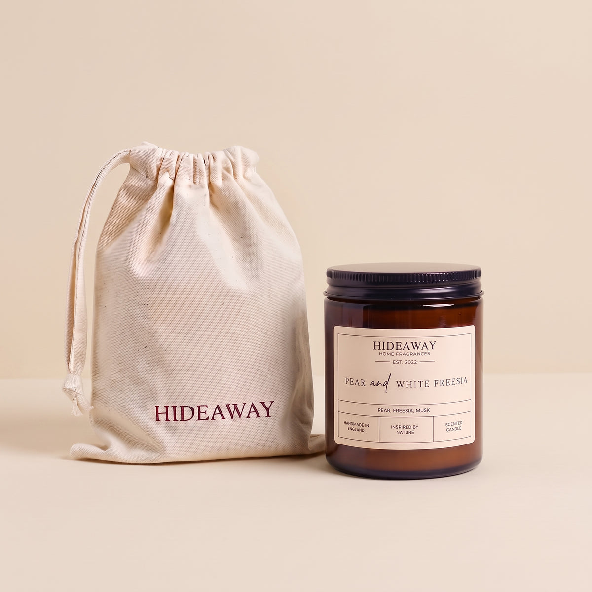 Fresh pear and white freesia aromatic candle in an amber glass jar creating an elegant spring atmosphere from Hideaway Home Fragrances