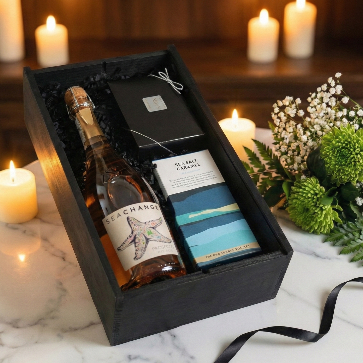 Sleek black wooden wine box slider opening to reveal eco-friendly sparkling wine and gourmet chocolates.