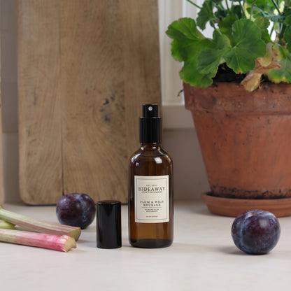 Fragrance notes graphic for Hideaway Home Fragrances plum and wild rhubarb room spray featuring crisp rhubarb, juicy peach, ripe plum, and wild blackberry.