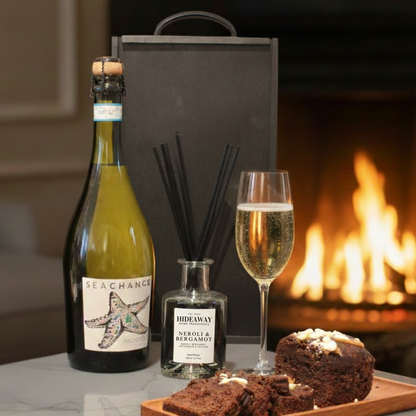 Vine & Velvet gift box featuring Sea Change Prosecco, Hideaway Reed Diffuser, and Cartwright & Butler cake tin inside a black wooden case.