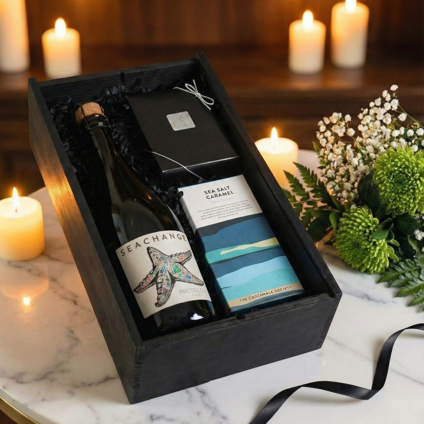 Choice of Sea Change Prosecco, Rosé, or Alcohol-Free bottles displayed next to luxury artisan chocolate gifts.