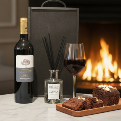 The Sensory Edit gift box featuring Finca Manzanos wine, Hideaway Reed Diffuser, and Cartwright & Butler cake tin inside a black wooden case.