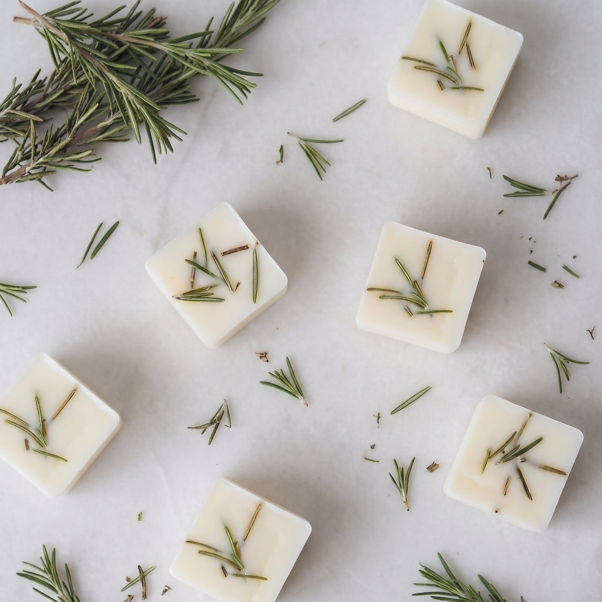 Close up of textured Hideaway Home Fragrances botanical wax melts with visible rosemary botanicals and citrus zest
