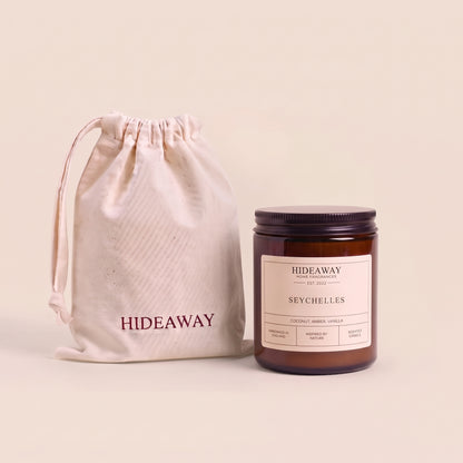 Exotic Seychelles aromatic candle in an amber glass jar creating a tropical beach getaway mood from Hideaway Home Fragrances