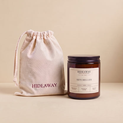 Exotic Seychelles aromatic candle in an amber glass jar creating a tropical beach getaway mood from Hideaway Home Fragrances