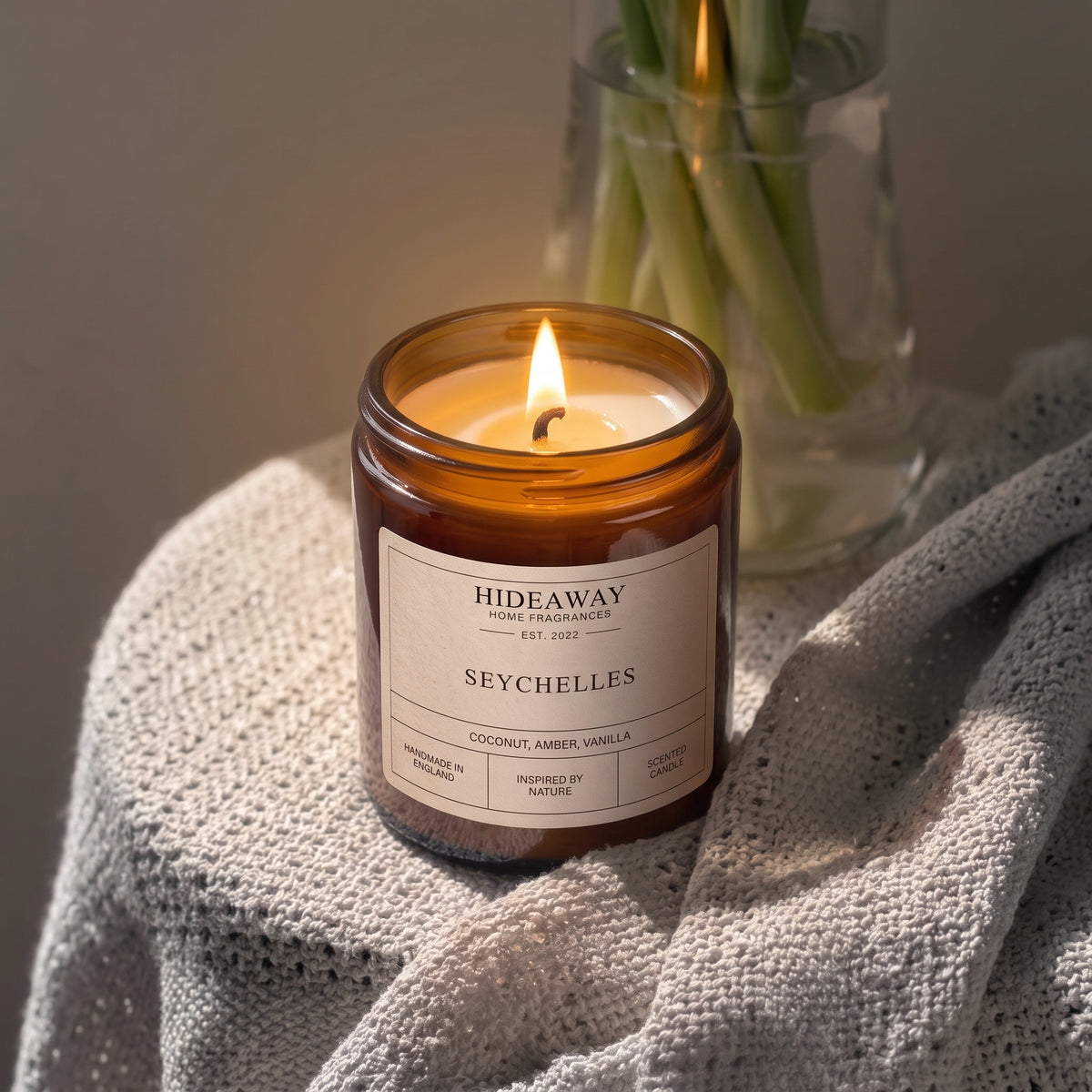 Luxury Seychelles amber glass jar candle styled on a sunny bathroom counter, Hideaway Home Fragrances