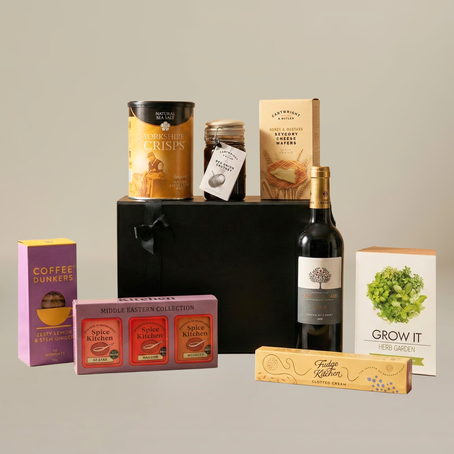 Gourmet food flatlay with coffee dunkers, cheese wafers, jar of chutney, and fresh herb growing pot.