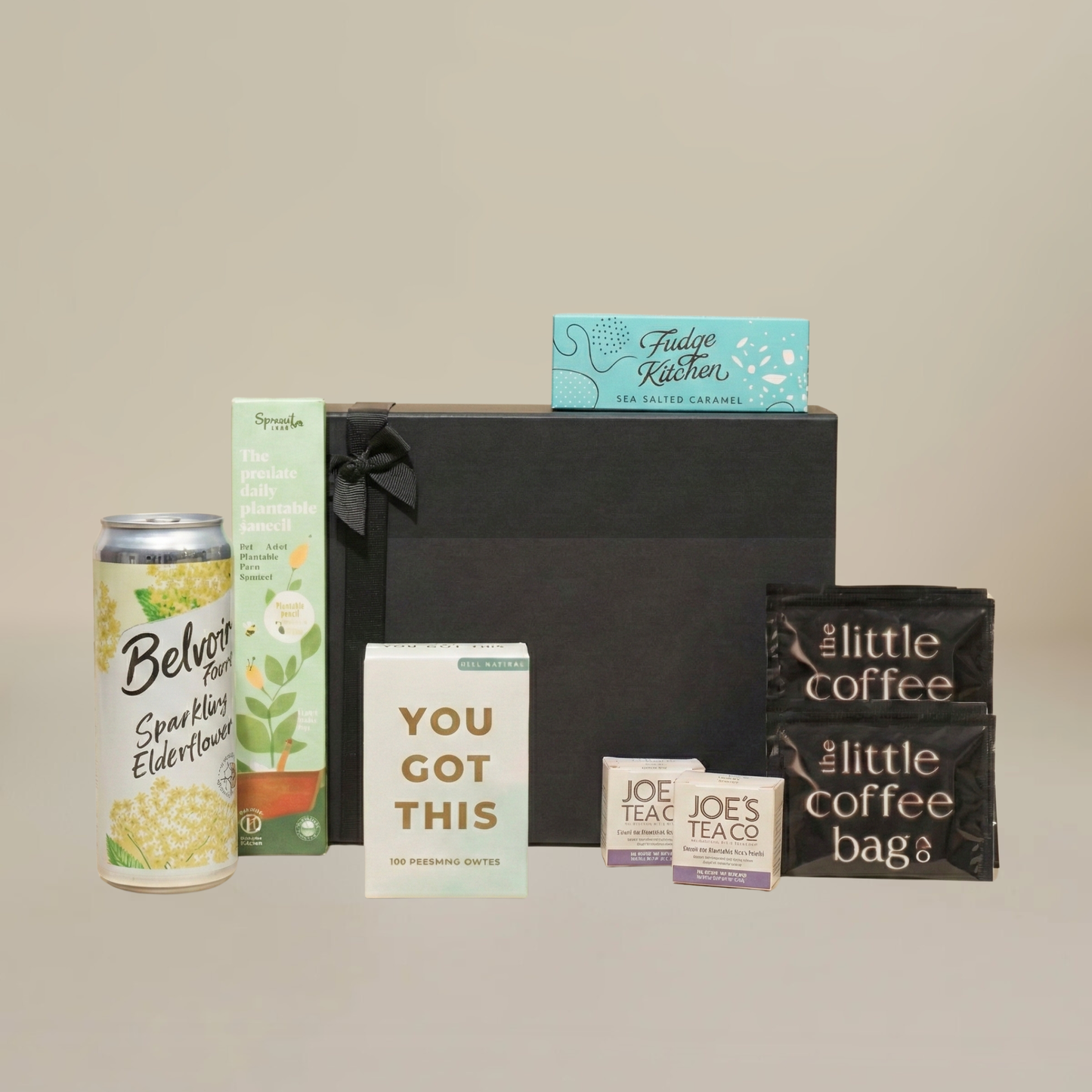 Mindfulness gift set flatlay with biodegradable tea temples, fudge slider, plantable stationery, and glass bottle soft drink.