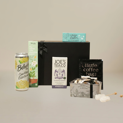 Eco-friendly gift set flatlay with crystal sugar sticks, biodegradable coffee bags, fudge slider, and plantable stationery.