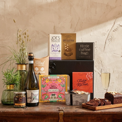 The Artisan Kitchen Collection luxury gift hamper featuring Sea Change Prosecco, Cartwright & Butler Chocolate Loaf Cake tin, and Spice Kitchen feasting kit
