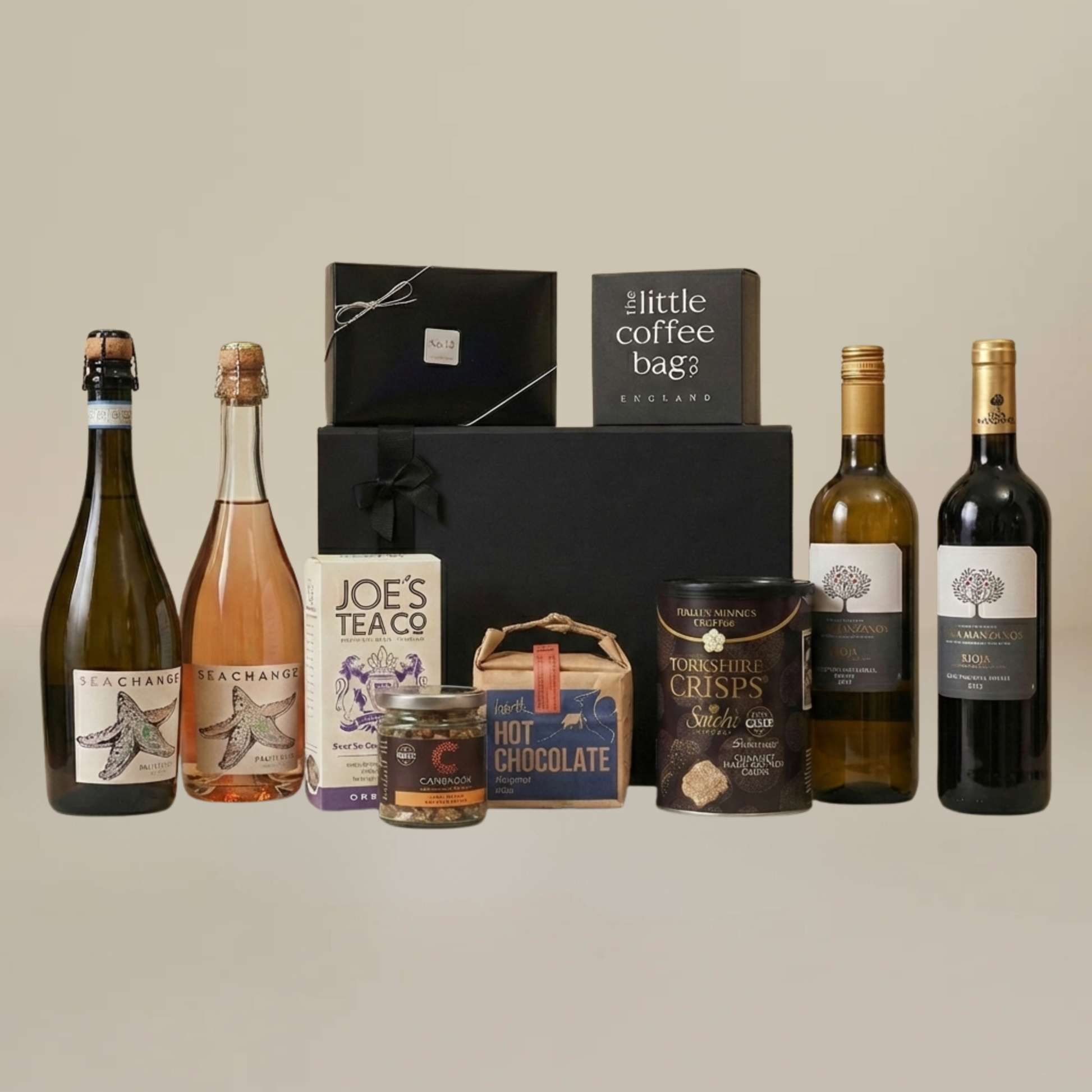 Gourmet wine and snack gift set with artisan chocolate, biodegradable coffee bags, caramelized peanuts, and Spanish wine bottles.