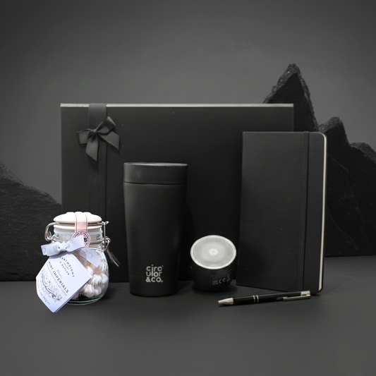 The Resonance Edit gift box featuring Swiss Peak stainless steel speaker, recycled travel mug, and A5 notebook.
